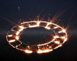 Ein Laser glüht komplexe Muster in Metallpulver. Ein Laser glüht komplexe Muster in Metallpulver.
